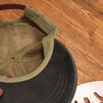 Load image into Gallery viewer, The &#39;MILLIGAN&#39; Two Tone Dad Hat.  A classic.  All time.  Never goes bad.  No expiration date.  Always gold my friends!  Delivered in a khaki cap with either a washed blue or washed black bill and button at far top.  Features a genuine leather strap with gold-colorored clasp at rear.  Super breathable liner on the inside sets this hat a couple notches above the rest.  This thing is yer&#39; go-to.  Just ask a dude in a tractor with a/c...and possibly a radio too.
